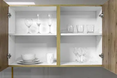a cabinet with wine glasses and plates on it at Amazing Marina View - Near the Beach! in Dubai