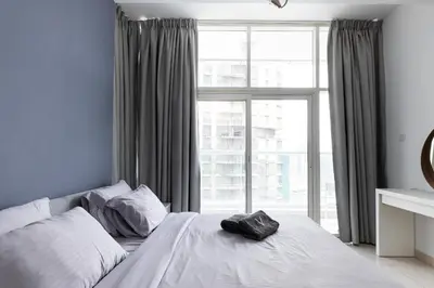 a bedroom with a bed and a large window at Amazing Marina View - Near the Beach! in Dubai