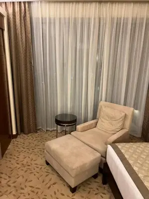 a hotel room with a bed and a chair and a table at Address Dubai Mall Fashion Avenue Studio 17 floor in Dubai