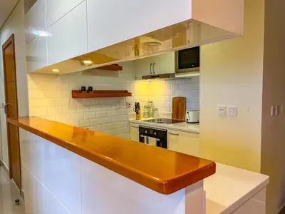 a kitchen with white walls and a wooden counter top at Exquisite, luxe 1BD Apartment, Unparalleled Sea Views, Prime Dubai Marina Location & Full Kitchen by 