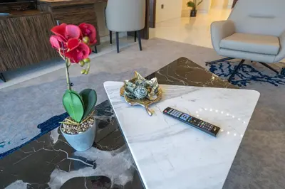 a table with a remote control and a flower on it at Exquisite Apartment Minutes Away from the Beach in Dubai