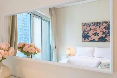 a mirror in a bedroom with a bed and a window at Charming Apartment in Central Dubai Marina in Dubai
