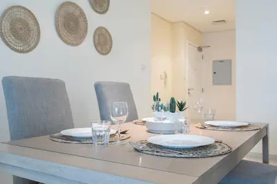 a dining room table with plates and glasses on it at Charming Apartment in Central Dubai Marina in Dubai