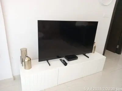 a flat screen tv sitting on a white cabinet at Beach apartment in Dubai in Dubai