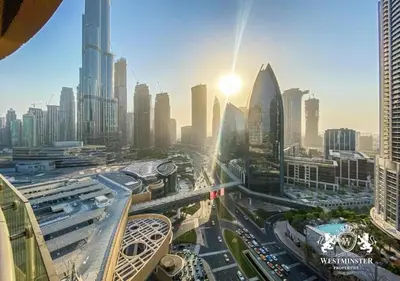 a view of a busy city with the sun in the sky at Deluxe Stay - Address Dubai Mall -The Residence in Dubai