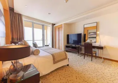a hotel room with a bed and a desk and a television at Deluxe Stay - Address Dubai Mall -The Residence in Dubai