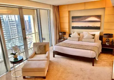 a bedroom with a king sized bed and a chair at Deluxe Stay - Address Dubai Mall -The Residence in Dubai