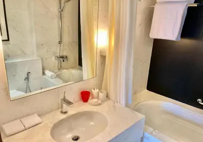 a white bathroom with a sink and a bath tub at Deluxe Stay - Address Dubai Mall -The Residence in Dubai