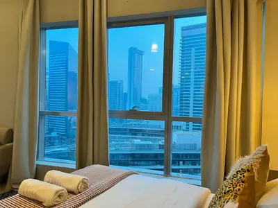 a bedroom with a window with a view of a city at Waterfront Yachts View Studio in Bay Central, Dubai Marina in Dubai