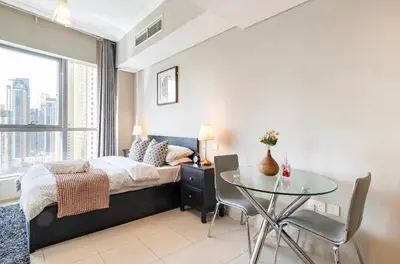 a bedroom with a bed and a glass table at Waterfront Yachts View Studio in Bay Central, Dubai Marina in Dubai