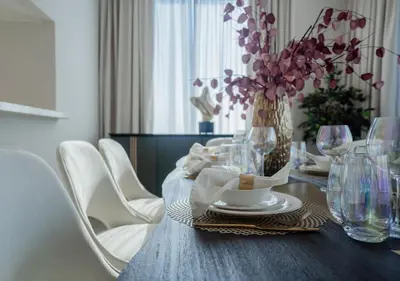 a dining room table with a vase of flowers and chairs at Nasma Luxury Stays - Harbour Gate Tower 1 in Dubai