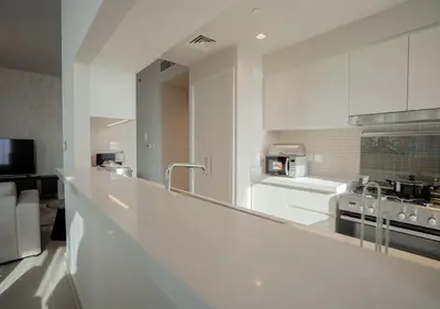 a kitchen with white cabinets and a counter top at Nasma Luxury Stays - Harbour Gate Tower 1 in Dubai