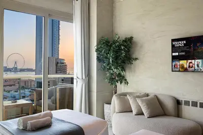 a living room with a couch and a large window at Lovely Dubai Eye & Sea View, 3 mints to beach in Dubai