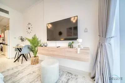 a living room with a large tv on a wall at Calm Studio at Carson C DAMAC Hills Dubailand by Deluxe Holiday Homes in Dubai