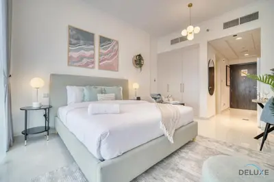 a bedroom with a large bed and a dining room at Calm Studio at Carson C DAMAC Hills Dubailand by Deluxe Holiday Homes in Dubai