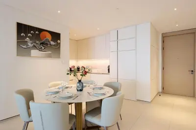a white dining room with a white table and chairs at Livbnb - Lush 2BR Suite with Sea and Ain View in Address JBR in Dubai