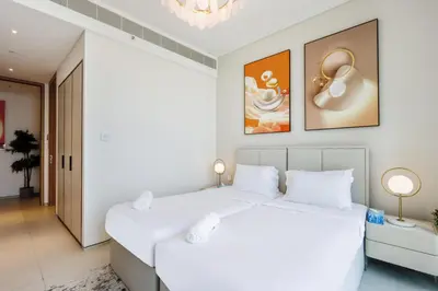 two beds in a bedroom with white walls at Livbnb - Lush 2BR Suite with Sea and Ain View in Address JBR in Dubai