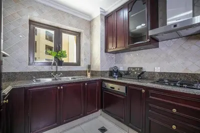a kitchen with wooden cabinets and a sink at 1BDR apartment with Burj Khalifa View I Walking Distance to Dubai Mall I Tajeer in Dubai