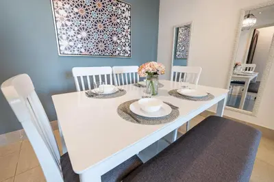 a white dining room table with white chairs and flowers at 1BDR apartment with Burj Khalifa View I Walking Distance to Dubai Mall I Tajeer in Dubai
