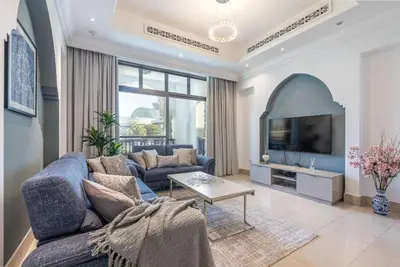 a living room with a blue couch and a tv at 1BDR apartment with Burj Khalifa View I Walking Distance to Dubai Mall I Tajeer in Dubai