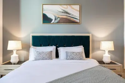 a bedroom with a large bed with two lamps at 1BDR apartment with Burj Khalifa View I Walking Distance to Dubai Mall I Tajeer in Dubai