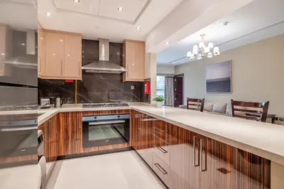 a kitchen with wooden cabinets and a stove top oven at Spacious 2BDR Apartment in Business Bay Habtoor City in Dubai