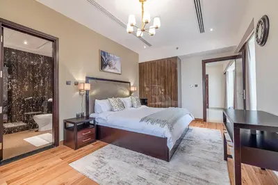 a bedroom with a bed and a desk and a bathroom at Spacious 2BDR Apartment in Business Bay Habtoor City in Dubai