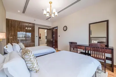 a bedroom with two beds and a desk and a mirror at Spacious 2BDR Apartment in Business Bay Habtoor City in Dubai