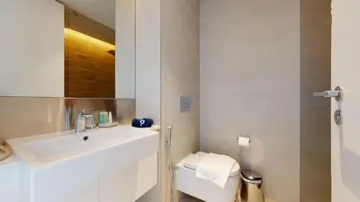 a white bathroom with a sink and a toilet at Bluewaters Island 2 and 1 BDR Apart with Sea Views in Dubai