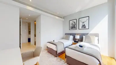 a hotel room with two beds and a chair at Bluewaters Island 2 and 1 BDR Apart with Sea Views in Dubai