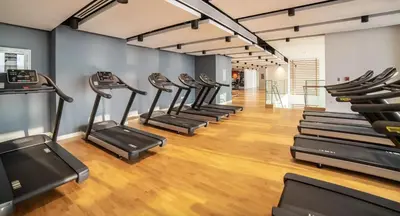 a row of cardio machines in a gym at Bluewaters Island 2 and 1 BDR Apart with Sea Views in Dubai