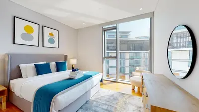 a bedroom with a bed and a large window at Bluewaters Island 2 and 1 BDR Apart with Sea Views in Dubai