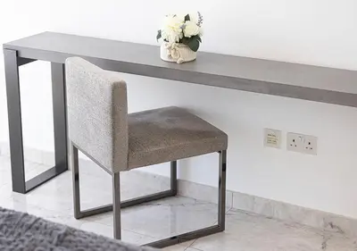 a table with a chair sitting under a table at Luxury Beachfront 2Bd Apt, Shams, JBR in Dubai