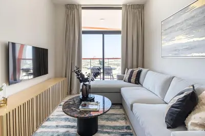 a living room with a couch and a tv at Frank Porter - Binghatti Avenue in Dubai