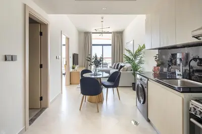 a kitchen and living room with a table and chairs at Frank Porter - Binghatti Avenue in Dubai