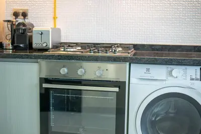 a kitchen with a stove and a washing machine at Breathtaking view compact & modern spacious studio in Dubai