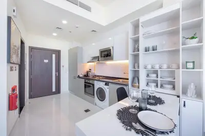 a kitchen with a sink and a washing machine at Breathtaking view compact & modern spacious studio in Dubai