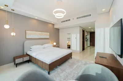a bedroom with a bed and a flat screen tv at Kasco Homes Waves Tower Business Bay in Dubai