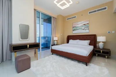 a bedroom with a large bed and a tv at Kasco Homes Waves Tower Business Bay in Dubai