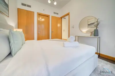 a large white bed in a room with a mirror at Hot Deal Modern 1BR at Iris Blue, Don't Miss Out by Deluxe Holiday Homes in Dubai