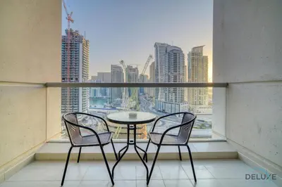 a table and two chairs on a balcony with a view at Hot Deal Modern 1BR at Iris Blue, Don't Miss Out by Deluxe Holiday Homes in Dubai