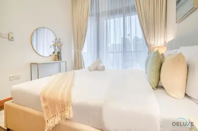 a bedroom with a large white bed with a window at Hot Deal Modern 1BR at Iris Blue, Don't Miss Out by Deluxe Holiday Homes in Dubai