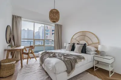 a white bedroom with a large bed and a desk at GuestReady - Bohemian Apt with Marina View in Dubai