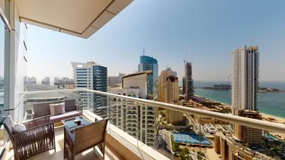 a balcony with two chairs and a view of the city at BR Luxe 1 BDR Apartment w/ Balcony & Sea Views in Dubai