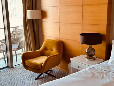 a bedroom with a chair next to a bed at Fashion avenue - Formerly Address Dubai Mall Residence in Dubai