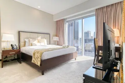 a bedroom with a bed and a tv and a window at Overlooking Marina Canal Views from Living to Bedroom, The Address Residences, Dubai Marina by Deluxe Holiday Homes in Dubai