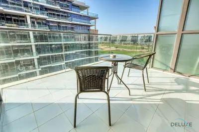 a patio with a table and chairs on a balcony at Luxuriant Studio at Golf Promenade 2A DAMAC Hills by Deluxe Holiday Homes in Dubai
