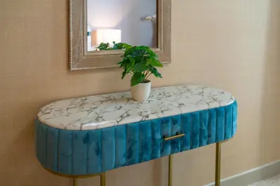 a blue and white stool with a mirror and a plant at BellaVista - Exuberant - 1BR - 29 Boulevard - Fountain Views in Dubai