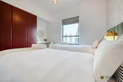 two white beds in a room with a window at Vogue 2BR at Shams 2 JBR by Deluxe Holiday Homes in Dubai