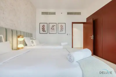 a bedroom with two beds with white sheets at Vogue 2BR at Shams 2 JBR by Deluxe Holiday Homes in Dubai